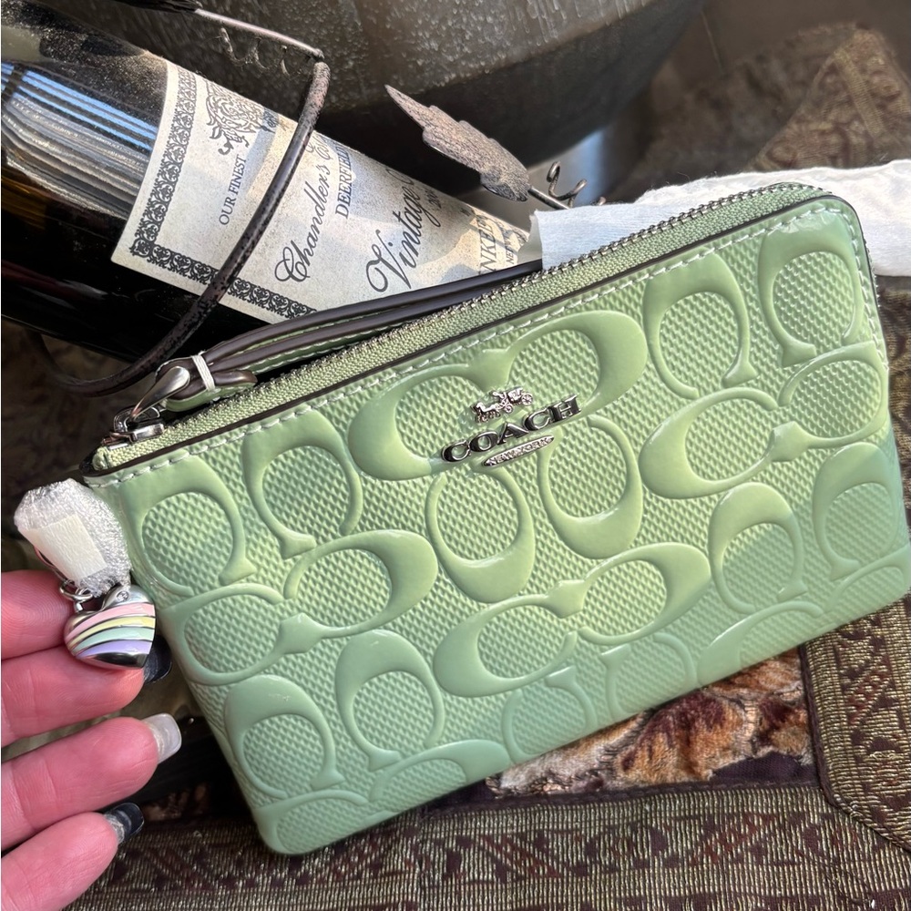 Authentic COACH patent signature leather zip top wristlet with a heart charm